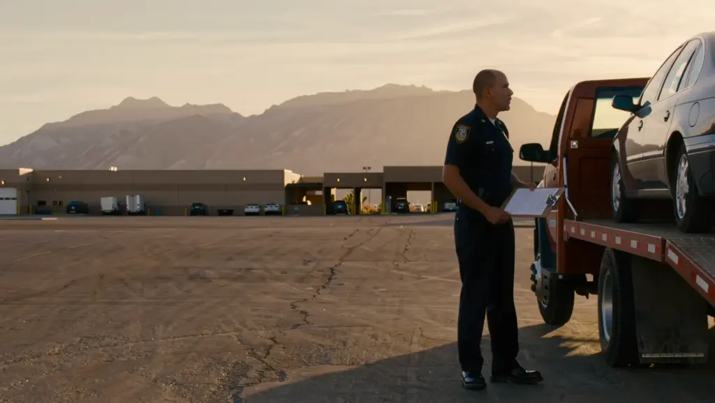 A vehicle being loaded onto a flatbed under a writ of execution while a deputy documents the seizure